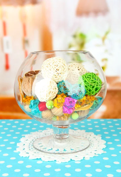 Naranjas secas, bolas de mimbre y otras decoraciones para el hogar en tazón de vidrio, sobre fondo brillante — Foto de Stock