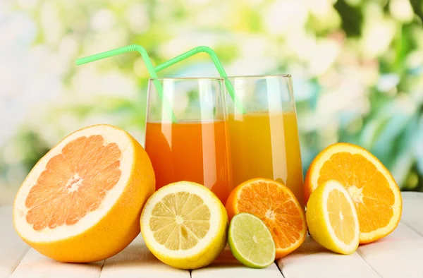 很多成熟的柑橘与自然背景上的木桌上的果汁 — 图库照片