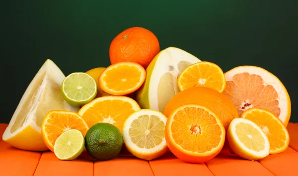 Hodně zralé citrusy na dřevěný stůl na tmavou barvu pozadí — Stock fotografie