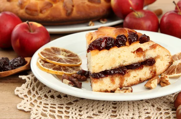 Fatia de torta caseira saborosa com geléia e maçãs, na mesa de madeira — Fotografia de Stock