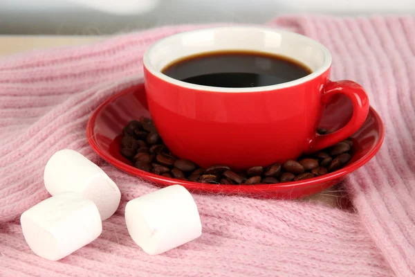 Cup of coffee with scarf on table in room — Stock Photo, Image