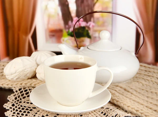 Cup of tea with scarf on table in room — Stock Photo, Image