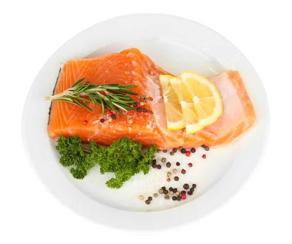 Filete de salmón fresco con hierbas y rodajas de limón en el plato, aislado en blanco — Foto de Stock