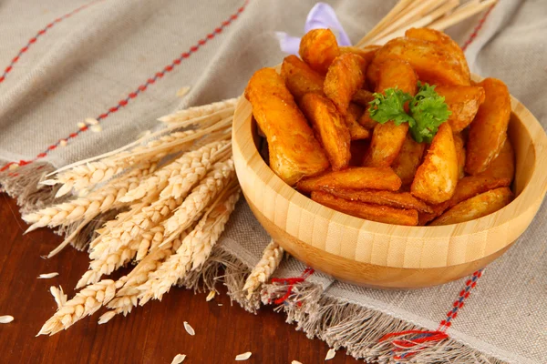 Appetitliche Dorfkartoffeln in Schüssel auf Holztisch in Großaufnahme — Stockfoto