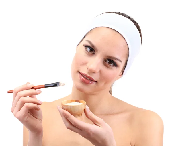 Young woman applying clay facial mask, isolated on white — Stockfoto