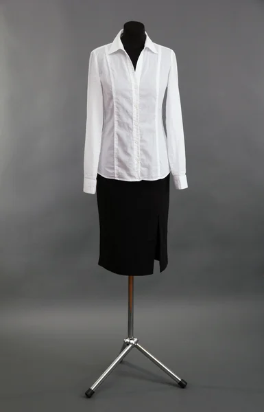 Blusa branca e saia preta no manequim no fundo cinza — Fotografia de Stock
