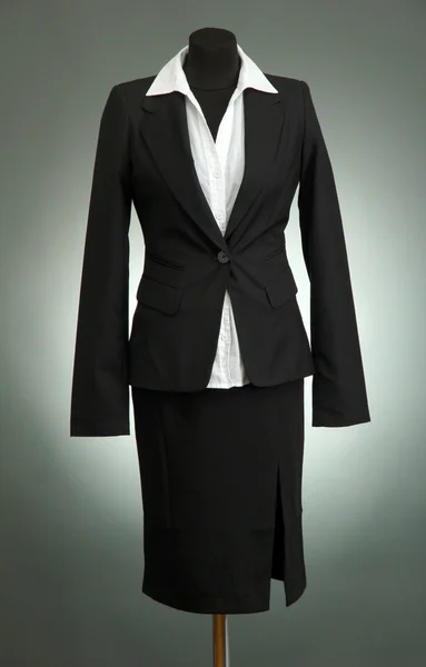 Białą bluzkę i czarną spódnicę z herbu na manekin na szarym tle — Zdjęcie stockowe