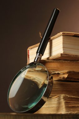 Büyüteç ve masa üzerine kitaplar