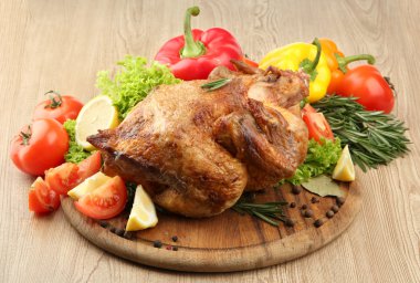 ahşap masa üzerinde plaka üzerinde sebze ile bütün kavrulmuş tavuk