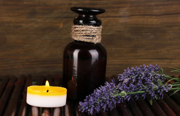 Láhev s aromatickými oleji s příslušenstvím pro relaxaci na dřevěný stůl na dřevěné pozadí — Stock fotografie
