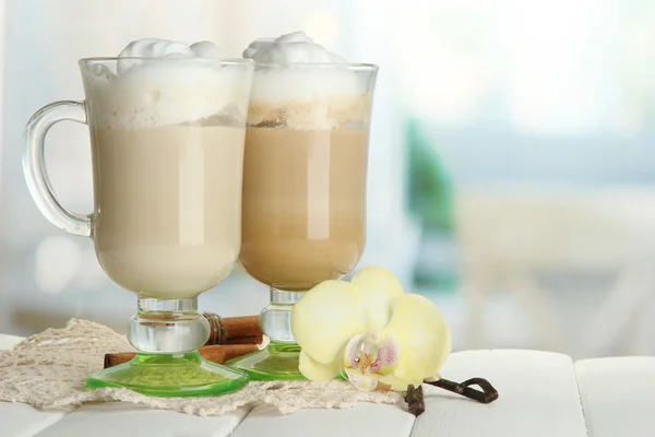 Café con leche aromática en vasos con especias, sobre mesa de madera — Foto de Stock