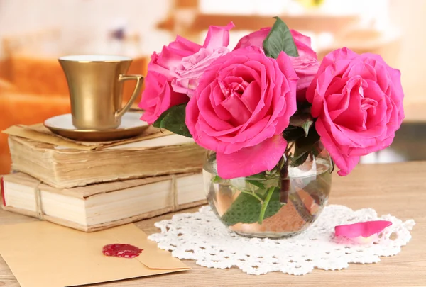 Belas rosas cor-de-rosa em vaso na mesa de madeira no fundo do quarto — Fotografia de Stock