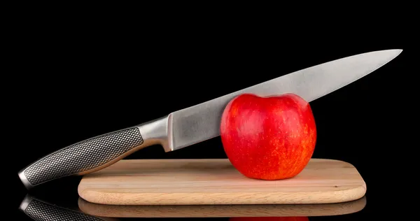 Manzana roja y cuchillo en tabla de cortar, aislado en negro —  Fotos de Stock