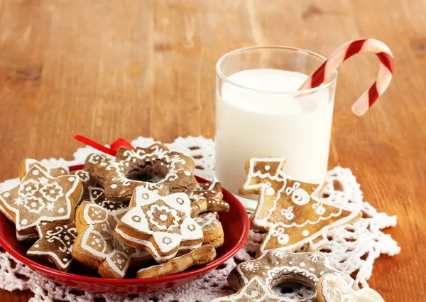 Dulces de Navidad en el plato y vaso de leche en la mesa de madera de cerca —  Fotos de Stock