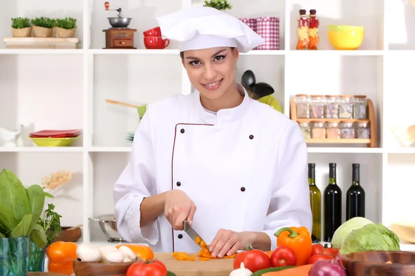 Young woman chef cooking in kitchen — Stock Photo, Image