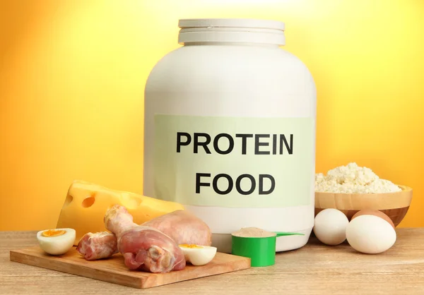 Burk proteinpulver och mat med protein, på gul bakgrund — Stockfoto