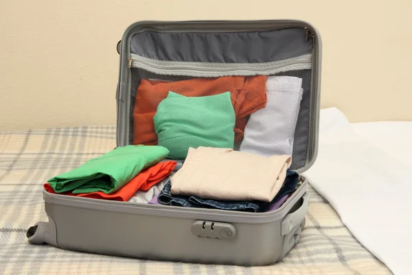 침대에 의류와 회색 가방을 열으십시오 — 스톡 사진
