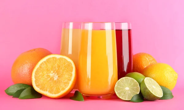 Bicchieri di juise con foglie e frutti su sfondo rosa — Foto Stock