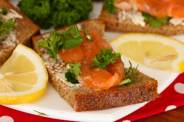 Panino al salmone su piatto, su fondo di legno, primo piano — Foto Stock