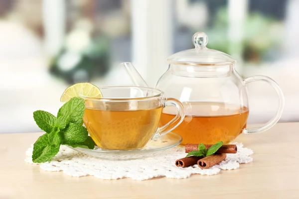 Xícara de chá com hortelã, limão e canela na mesa no quarto — Fotografia de Stock