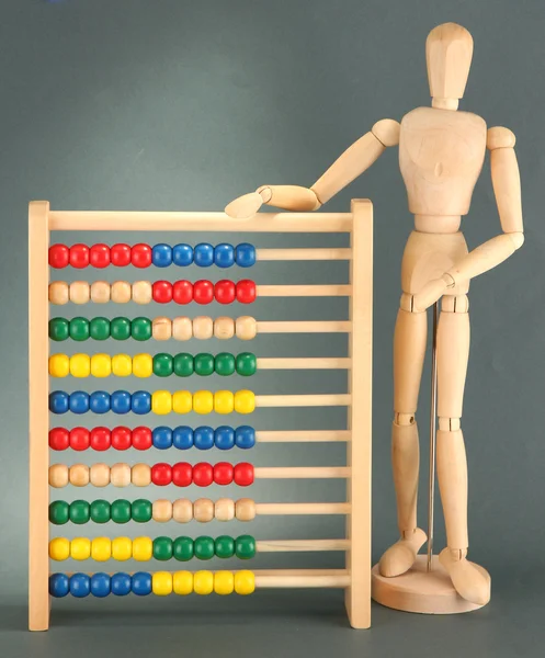 Heldere speelgoed abacus en houten pop, op grijze achtergrond — Stockfoto