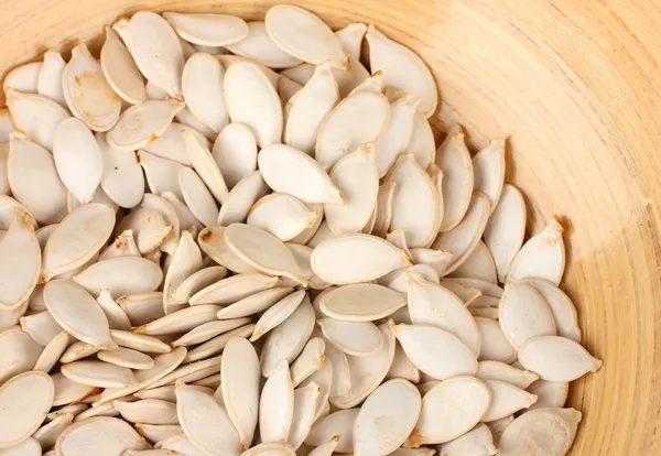 Pumpkin seeds in wooden bowl, close up — Stock Photo, Image