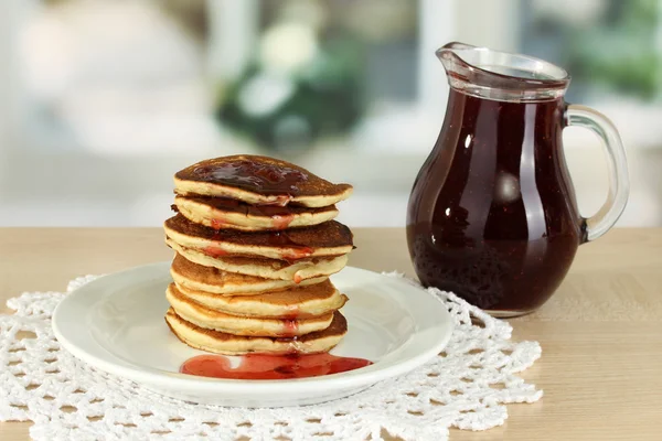 Sweet pancakes on plate with jam on table in kitchen — Stock Photo, Image