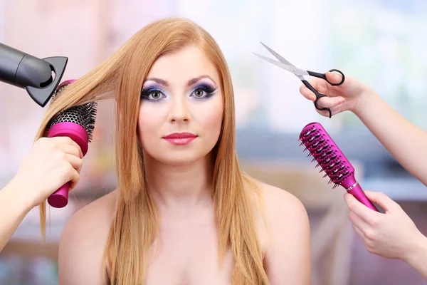 Güzel kadın ve fırçalar, makas ve güzellik salonları, saç kurutma makinesi ile el — Stok fotoğraf