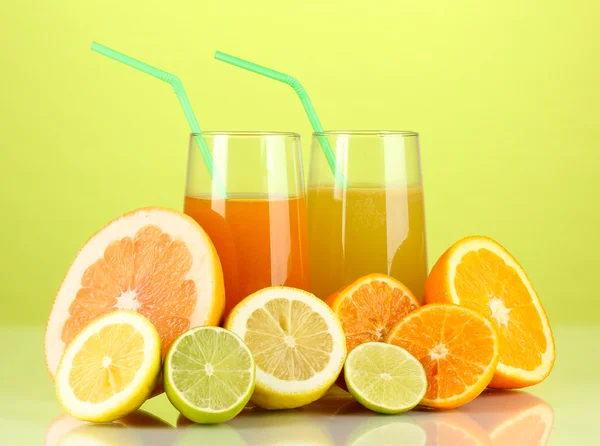 Lots ripe citrus with juices on green background — Stock Photo, Image