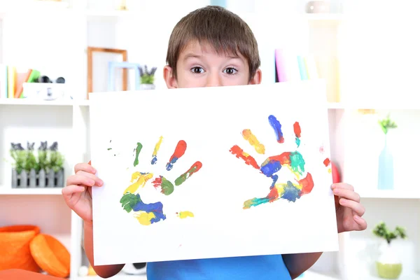 Lindo niño con su colorida huella de mano — Foto de Stock