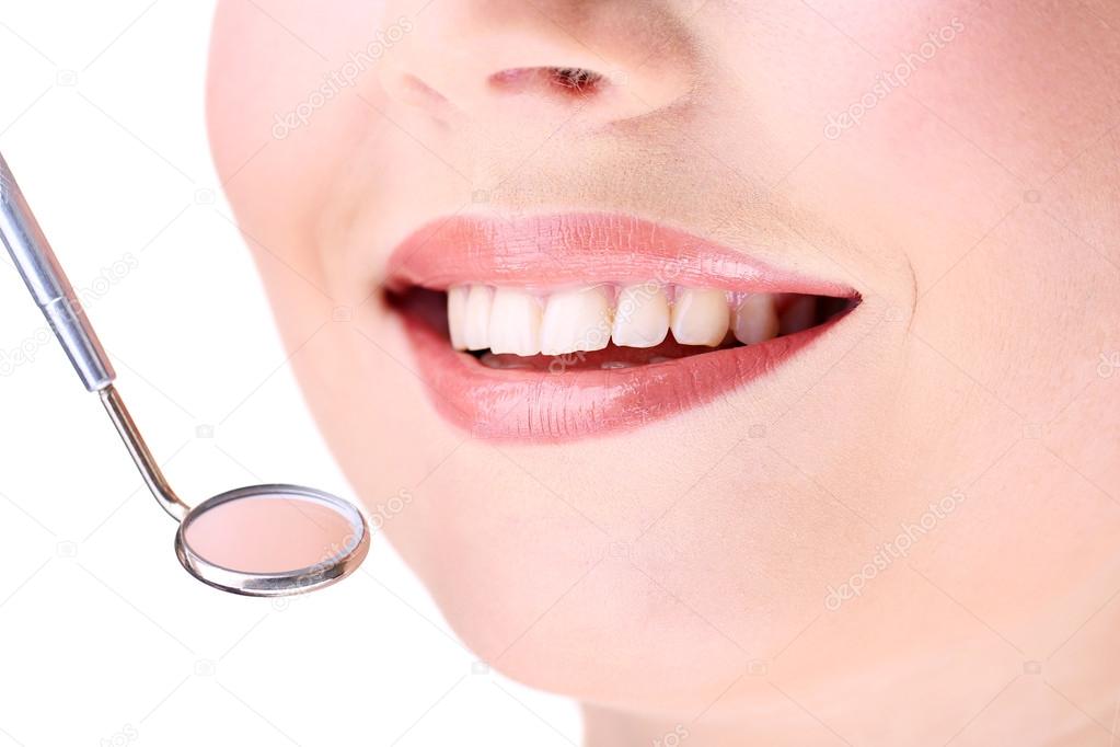 Woman smiling with teeth and dental mirror, isolated on white