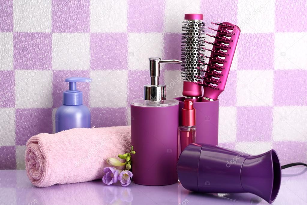 Hair brushes, hairdryer and cosmetic bottles in bathroom