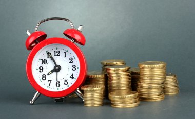 gri arka plan üzerinde paralar ile çalar saat