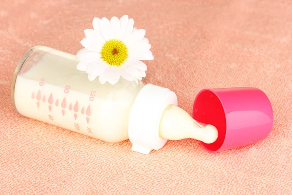 Bottiglia di latte per bambini su asciugamano rosa — Foto Stock