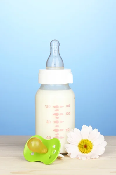 Babyflasche mit Milch auf blauem Hintergrund — Stockfoto