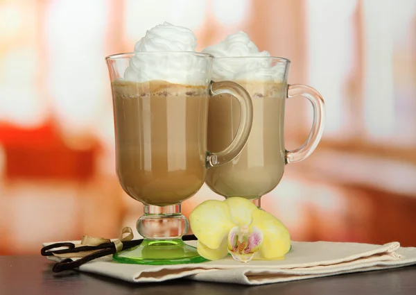 Café con leche fragante en vasos tazas con vainas de vainilla, en la mesa en la cafetería — Foto de Stock