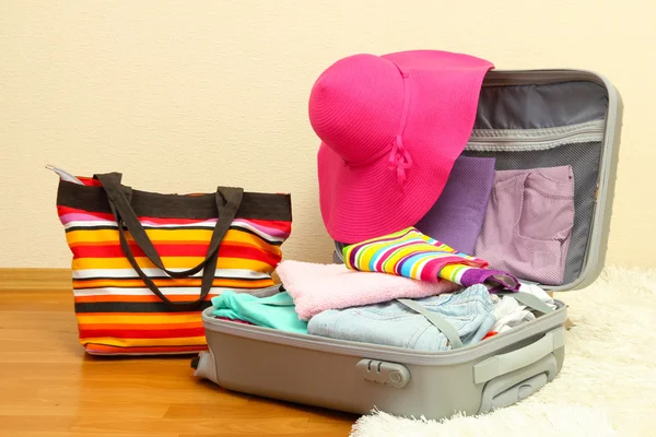 Valise ouverte en argent avec vêtements dans la chambre — Photo