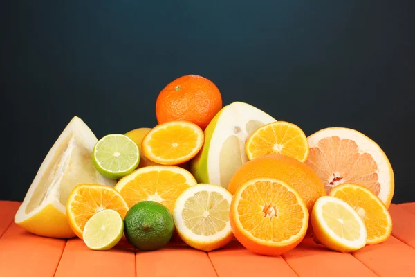 Lots ripe citrus on wooden table on dark color background — Stock Photo, Image