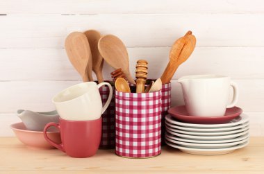 Cups, bowls nd other utensils in metal containers isolated on light background