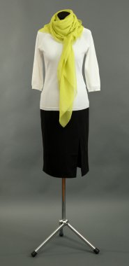 manken üzerinde gri arka plan üzerinde beyaz bluz, siyah etek ve Yeşil fular