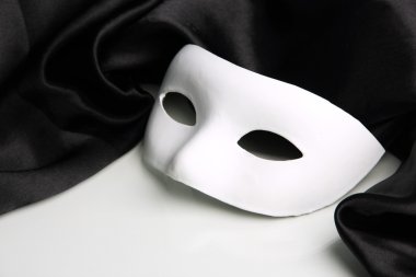 Beyaz maske ve siyah ipek kumaş üzerine beyaz izole,