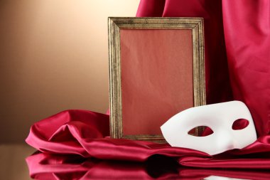 Beyaz maske, boş çerçeve ve kırmızı zemin üzerine altın ipek kumaş