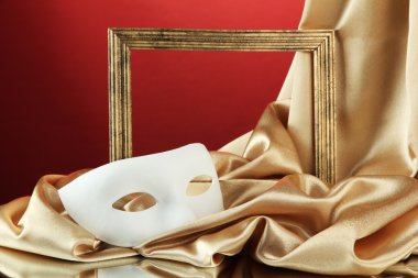 Beyaz maske, boş çerçeve ve kırmızı zemin üzerine altın ipek kumaş