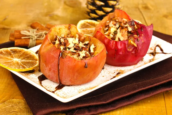 Baked apples on plate on wooden table — Stock Photo, Image
