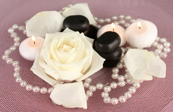 Piedras de spa con flores y velas en agua en el plato — Foto de Stock
