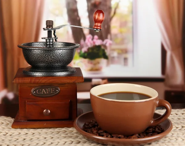 Cup of coffee with scarf and coffee mill on table in room — Stock Photo, Image