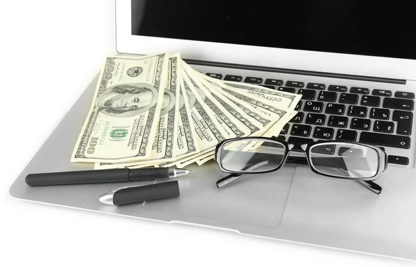 Geld met glazen en pen op laptop geïsoleerd op wit — Stockfoto