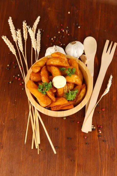 Appetizing village potatoes in bowl on wooden table close-up — Stock Photo, Image