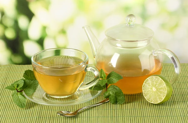 Tazza di tè con menta e lime sul tavolo su sfondo luminoso — Foto Stock