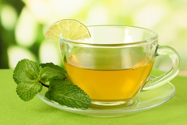 Cup of tea with mint on table on bright background — Stock Photo, Image